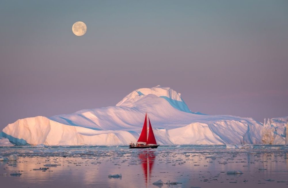عکس/ قایق بادبانی در برابر کوه یخ در عکس روز نشنال جئوگرافیک